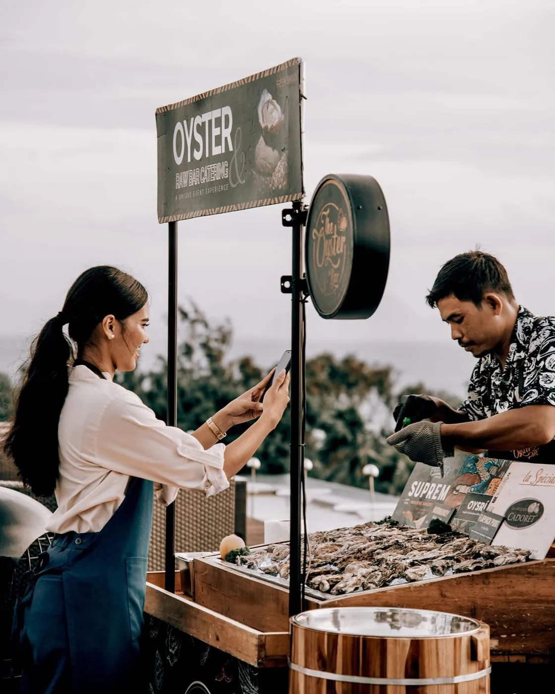 A shucker opening oysters for guests at a private party